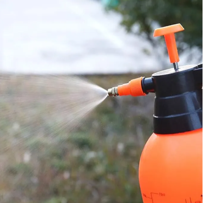 Orange and black pressure washer being used outdoors.