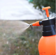 Orange and black pressure washer being used outdoors.